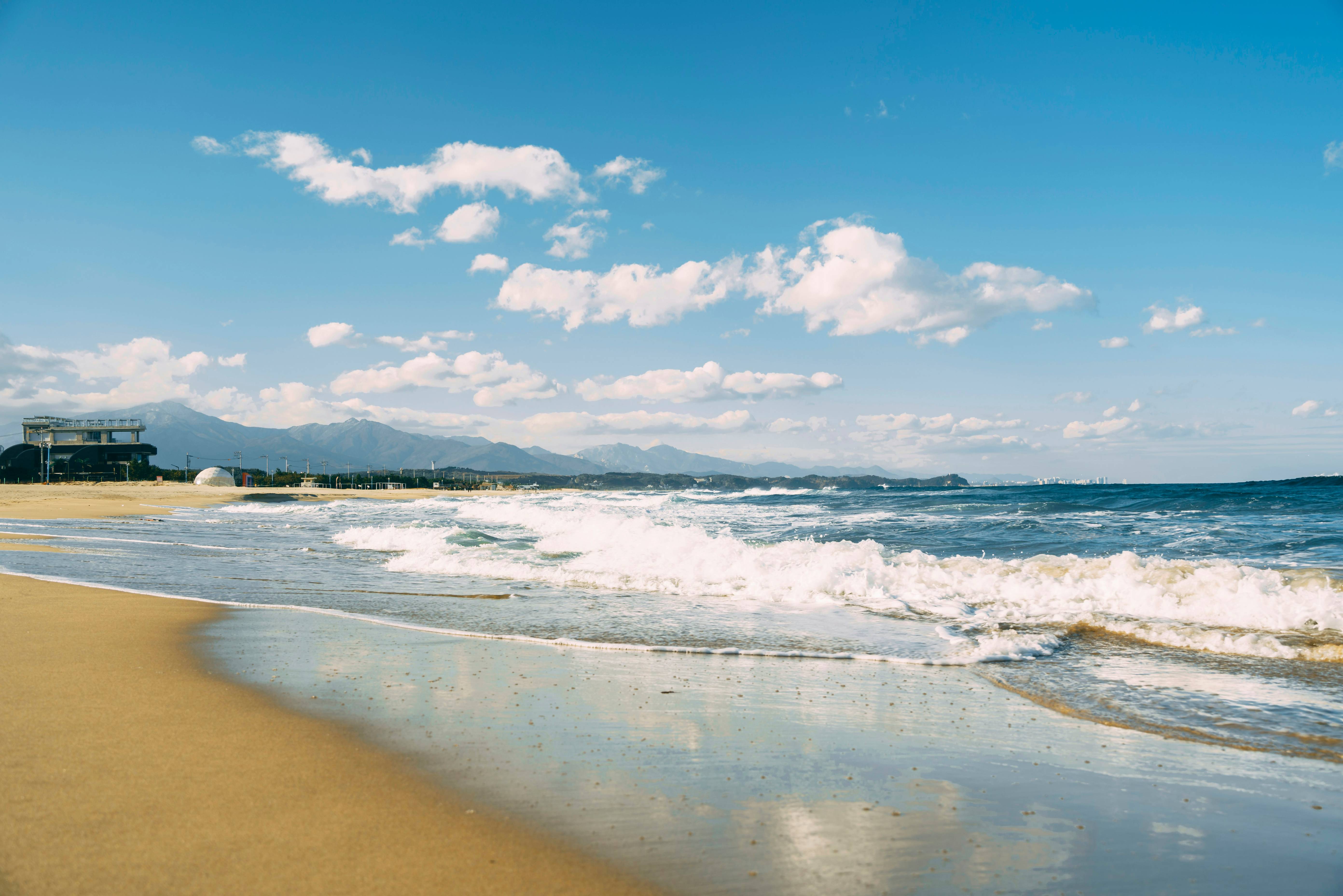 A sandy beach with waves coming in to shore
