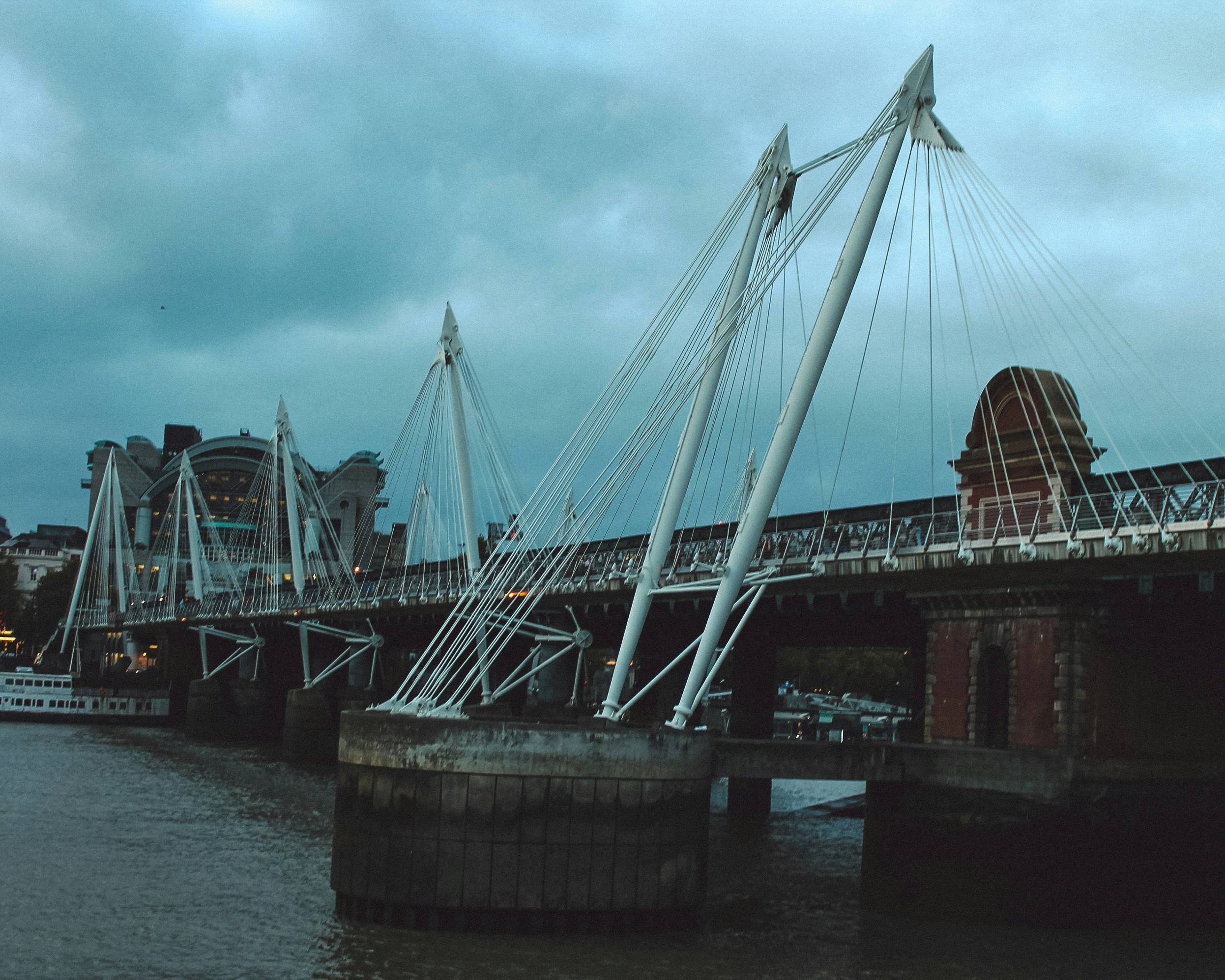 a bridge over a body of water under a cloudy sky