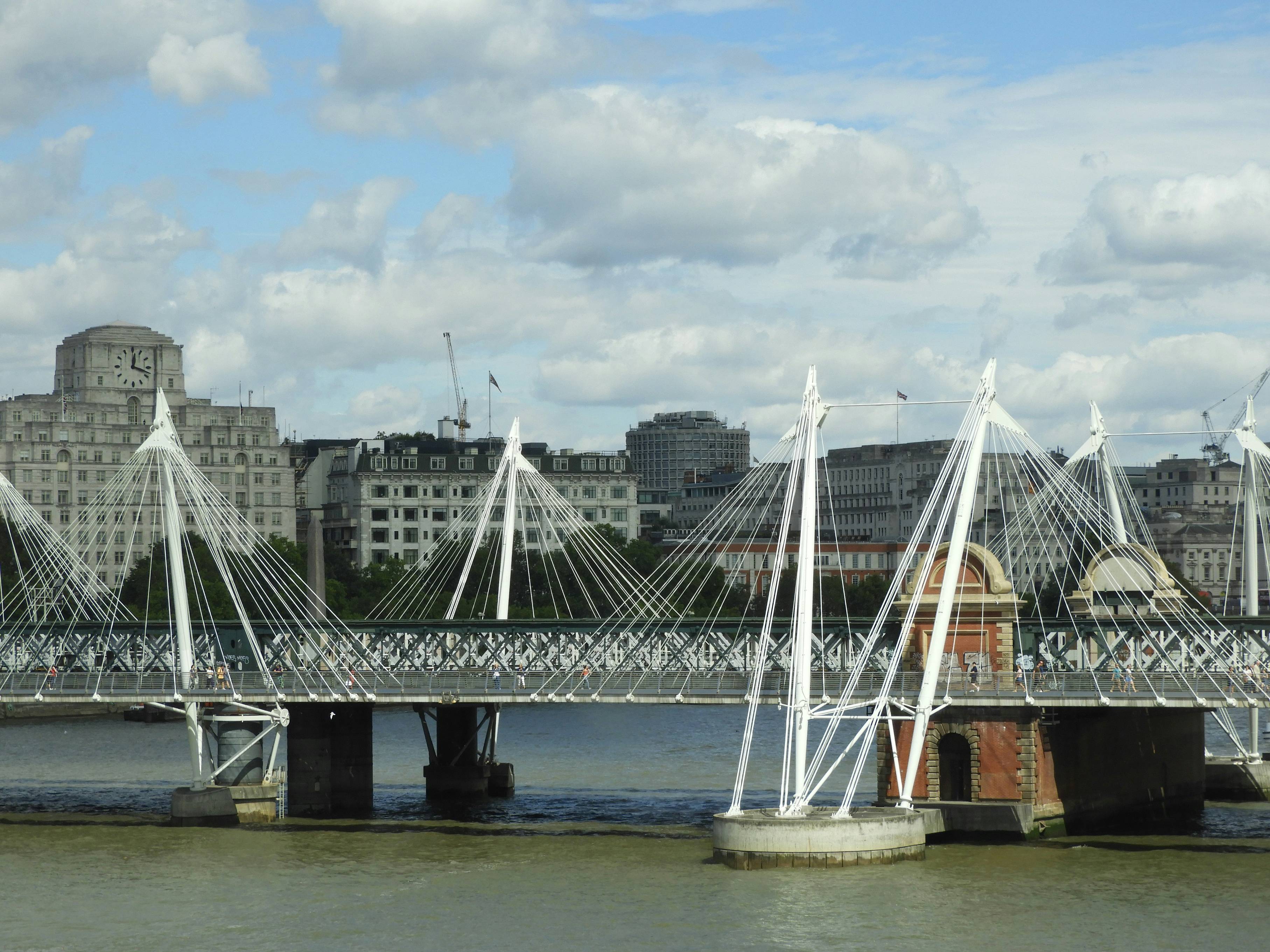 a bridge over a body of water with tall buildings in the background